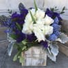 White and purple floral arrangement in a rustic wooden box