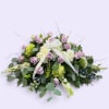 Lavender roses and white hydrangeas in a low floral arrangement with a ribbon bow