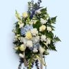 Standing floral spray with white roses, blue hydrangea, and ribbon