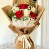 Bouquet of red and white roses wrapped in brown paper
