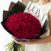 Large bouquet of red roses wrapped in black paper with a love card