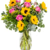 Bouquet of pink roses and yellow sunflowers in a clear glass vase