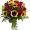 Bouquet of red roses and yellow sunflowers in a glass vase