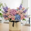 This vibrant one-sided arrangement features soft pink hydrangeas, &amp; vibrant blue hydrangeas