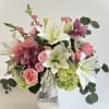Pink roses and white lilies arranged in a gray vase