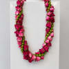 Celebrate a special milestone with a beautifully crafted rose and berry lei
