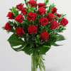 A lush mound of 18 rich red roses arranged in a tight