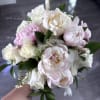 Soft blush peonies and creamy white roses come together in a compact