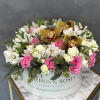 Pink and white roses with orchids in a round hatbox