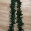 Two dark green leaf garlands laid on a wooden floor