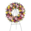 Large multicolored floral wreath on a metal stand