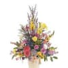 Mixed bouquet of colorful flowers in a cream vase