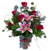 Bouquet of red roses and pink lilies in a glass vase