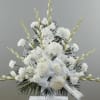 White funeral spray with ribbon on a stand