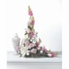 Pink and white floral spray beside a white urn