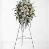 White floral standing spray on an easel with ribbon streamers