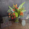 Bright orange roses and playful butterfly picks give this mixed-color bouquet a
