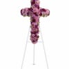 Cross-shaped floral tribute on a white easel with pink and purple flowers