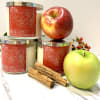 Three spiced apple candles with apples and cinnamon sticks