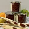 Three scented candles with citrus and dried floral accents