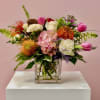 A vibrant arrangement featuring striking pincushions surrounded by soft pink and white