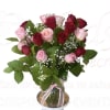 Bouquet of red and pink roses in a glass vase with a pink ribbon