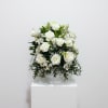 White rose arrangement in a clear pedestal vase