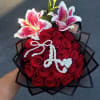 Red, long stem roses complemented by two large stargazing lilies and initial