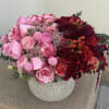 Pink and red rose arrangement in a textured stone vase