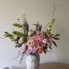 Modern ceramic vase full of Spray roses, Delphinium, and other mixed roses