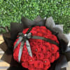 Large bouquet of red roses wrapped in black paper with a black ribbon