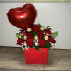 Red rose arrangement in a red gift box with a heart balloon and chocolates