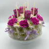 Round floral cake with purple roses and white daisies on a pedestal stand