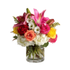 Mixed bouquet of lilies, roses, and white daisies in a glass vase