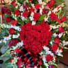 Large red rose and orchid standing spray with a black-and-red ribbon bow