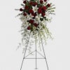 Standing floral spray with red roses and white lilies on a metal easel