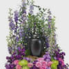 Purple and pink floral arrangement in a black urn vase
