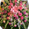 Large bouquet of pink and lavender roses with white orchids and a pink ribbon