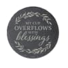 Round black stone plaque with the words "My cup overflows with blessings"