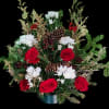 Red roses and white daisies in a low holiday arrangement with pinecones
