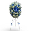 Blue and white funeral wreath on a standing easel with ribbon