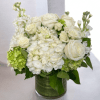 White roses and hydrangeas arranged in a glass vase