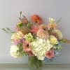 Pastel mixed flower arrangement in a textured glass vase