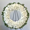 White floral wreath on a black stand