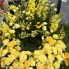 Large yellow floral wreath with roses, carnations, and snapdragons