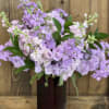 Lavender and pale pink flowers in a dark vase