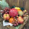 Fruit basket with apples, grapes, kiwi, oranges, and a pineapple