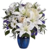 White lilies and daisies in a blue glass vase