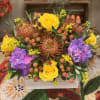 Bright mixed bouquet with yellow roses and purple hydrangeas in a wooden box