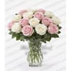 Pink and white roses arranged in a clear glass vase